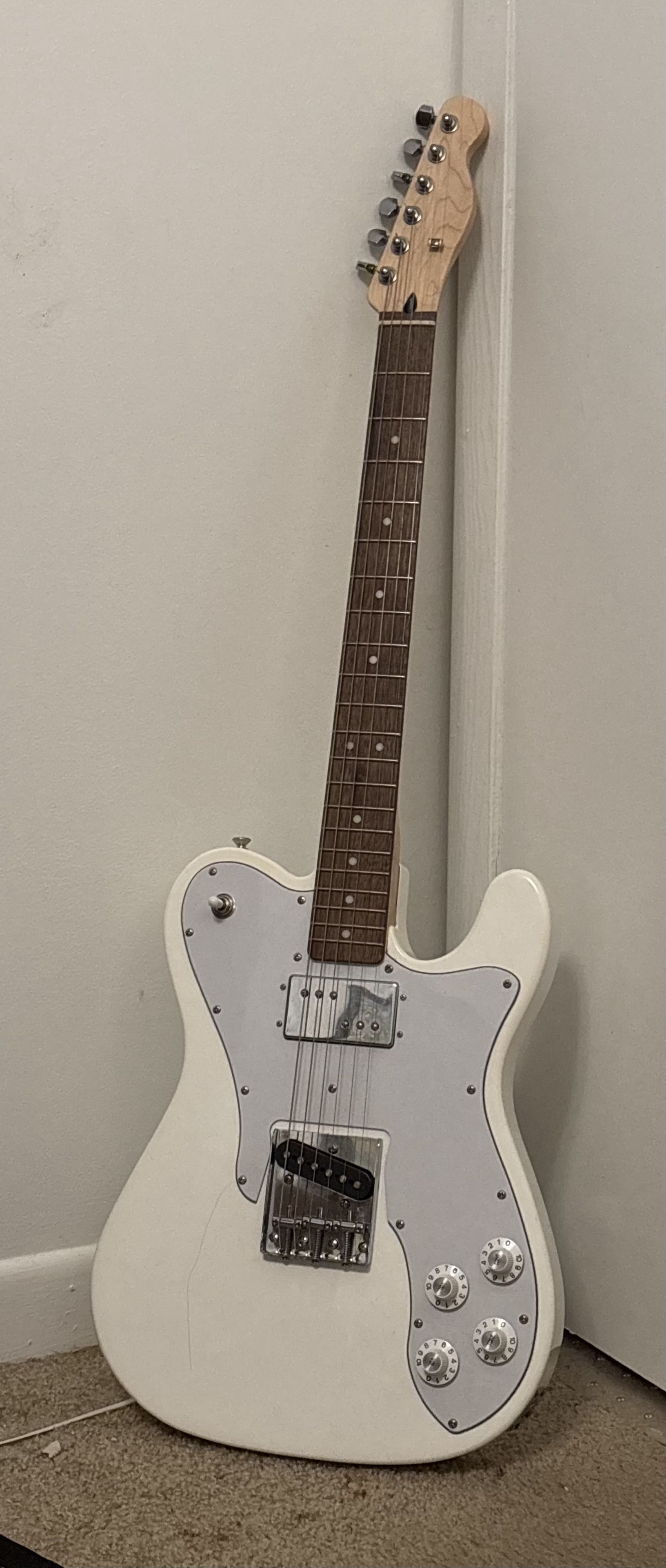 a white electric 6-string guitar with two pickups